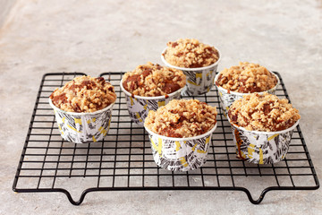 Muffins with apples and cinnamon on wooden background