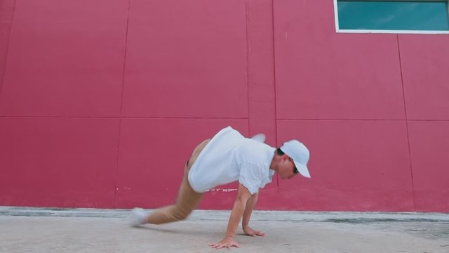 Dancing man performing various freestyle dance outdoors in street wall having fun. Modern lifestyle, happiness concept. breakdancing, hiphop dancing, street dancing.