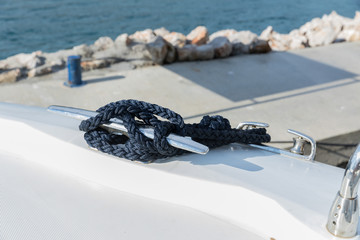 Detail of an anchor rope on a yacht, Stainless steel boat mooring cleat with knotted rope mounted...