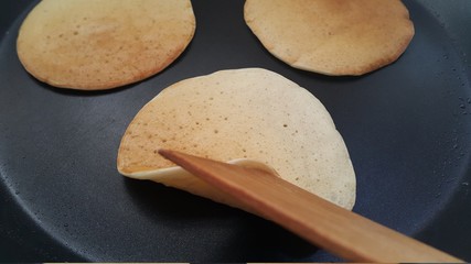 Delicious thin pancakes on a non-stick pan. Top view. Flat lay.  Cooking process. Pancakes recipe.