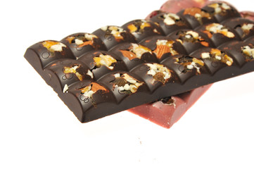 Two bars of milk and pink chocolate with raisins and dried apricots close-up