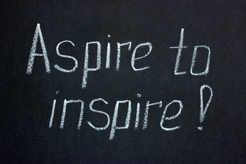 Obraz premium Chalk lettering on a dark board exclamation Aspire to inspire. Motivating phrase