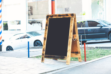Blank wooden sandwich board at the street near skyscrapers