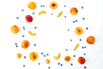 Sliced peaches with cherry and blueberry on white background. Top view