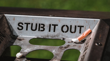 Obraz premium Stub it out - close up of a cigarette stub on a waste bin