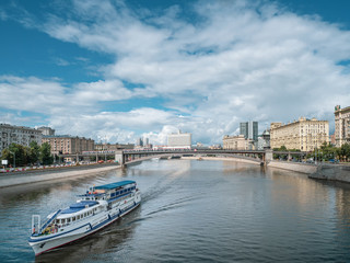 Large two-story white liner with tourists goes along Moscow river