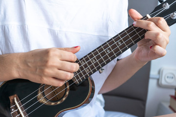 Fototapeta na wymiar Young woman playing ukulele