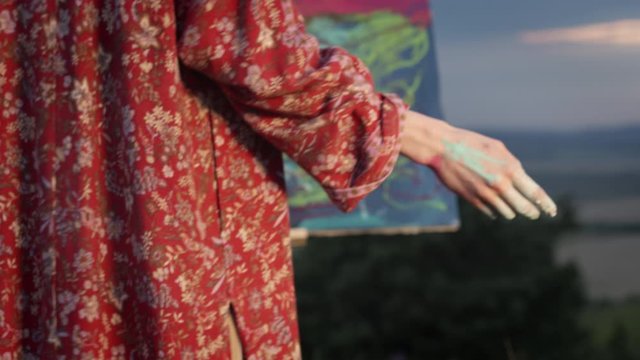 Girl Artist Paints Picture With Her Hand Dipped In Paint.