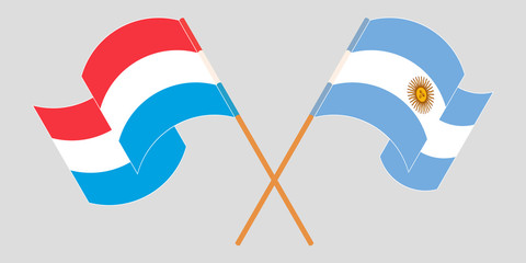 Crossed and waving flags of Luxembourg and Argentina