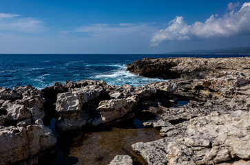 Fototapeta na wymiar Waves crash on the rocky shore of the Mediterranean Sea on the Akamas Peninsula in the northwest of the island of Cyprus.