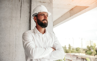 Confident architect standing on construction site