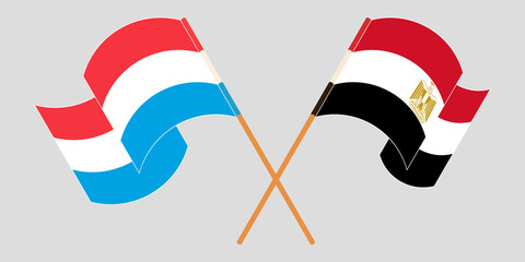 Crossed and waving flags of Luxembourg and Egypt