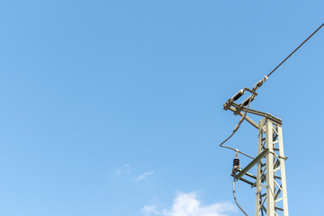 Obraz premium Mast einer Oberleitung vor blauem Himmel