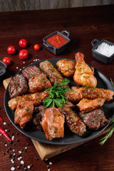 Assorted delicious grilled meat with vegetable. Mixed grilled bbq meat with vegetables. Set of shish kebabs or barbecue shashlik collection. Baked potatoes and fresh tomatoes. Various sauces for meat.