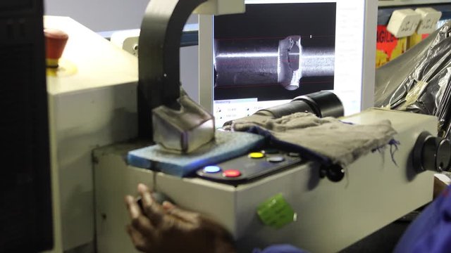 African woman working on a cutting polishing machine for diamonds