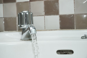 Water flowing from faucet in bathroom