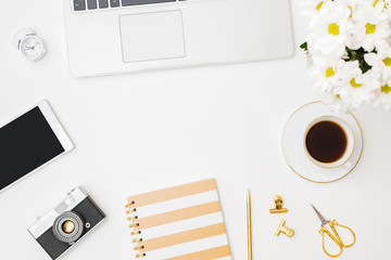 Flat lay blogger or freelancer workspace with a notebook, laptop a cup of coffee on a white background