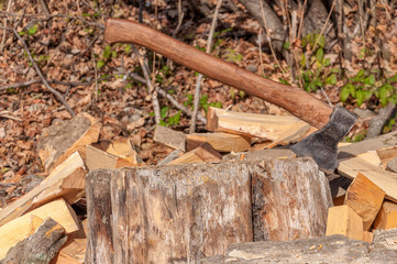 The ax for splitting firewood after work. The logs lie near.