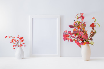 Home interior with decor elements. Mockup with a white frame, colorful autumn leaves in a vase on a light background