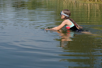 a young girl swims in the lake