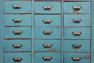 Old turquoise and brown colored wooden cabinet with drawers background