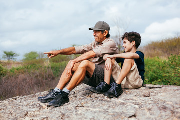 Latin grandfather with his grandson enjoying the natural landscape. Concept of grandparents and grandchildren in outdoor activity