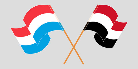 Crossed and waving flags of Luxembourg and Yemen