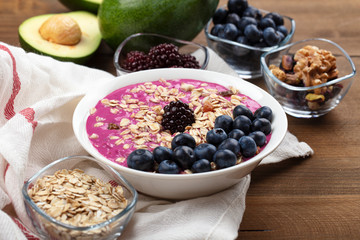 Breakfast bowl with cereals, fruit, oats, blueberries. Healthy morning meal on a wooden background. Top view.