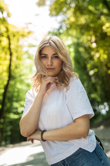 Obraz premium Pretty happy woman spending her time in green park