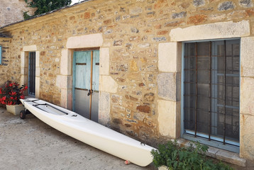 Greek stone house village style with a kayak in front