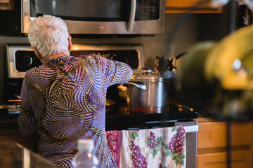 old woman cooking dinner for family 