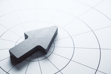 Metal arrow on abstract gray table.