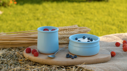 Yogurt with berries and sheaf of wheat ears