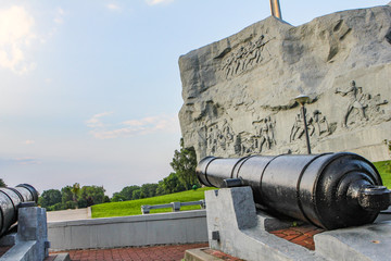 the ship's cannon is aimed at the sky against the background of a large gray monument.