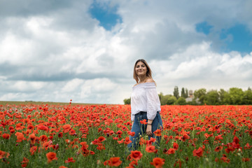 Fototapeta na wymiar Ukrainian lady walking along a poppy field, the concept of sensuality, lifestyle