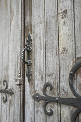 Medieval closed old wooden door with ironwork handle and hinges. Detail of a gate, building in the netherlands. 
