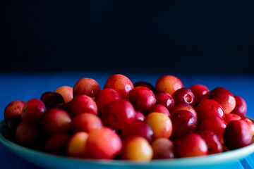 Close-up photo of red cherries on plate in studio
