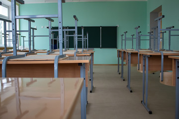 Empty classroom, inverted chairs on desks, distance learning during the pandemic.