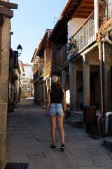 Attractive young female visiting an ancient fishing village in Galicia, Spain and wearing a reusable facemask as a precaution due to coronavirus outbreak