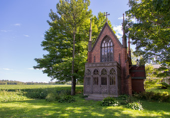 Beautiful red brick gothic revival 1868 Notre-Dame-de-Grace chapel seen during a sunny summer day,...