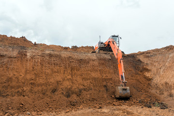 The construction site excavator digs a deep pit. Digger. Construction machinery. Excavation at a...