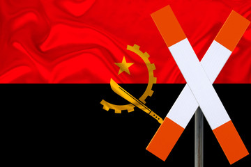 sign, stop, attention on the background of the silk national flag of Angola, the concept of border and customs control, violation of the state border, tourism restrictions