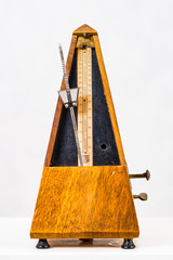 Old vintage metronome on light background