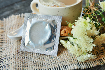 cup of aromatic coffee, condom and a bouquet of flowers on white, Romantic date, invitation, sweet wish card text space concept
