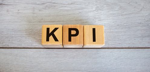 Concept word KPI, 'key performance indicator' on cubes on a beautiful white wooden table. Business...