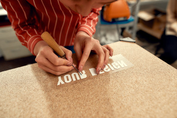 Quality and Advancement. Cropped shot of woman carefully removing the backing from advertisement...