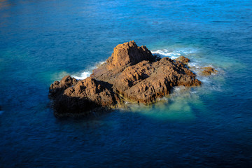 long exposure photo of a stone island in the ocean