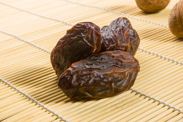 Big luxury dried date fruit on the bamboo mat, kurma ramadan kareem concept, close up.