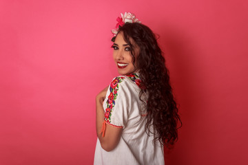 Mexicana latina joven en blusa típica folclórica de flores con adorno en el cabello