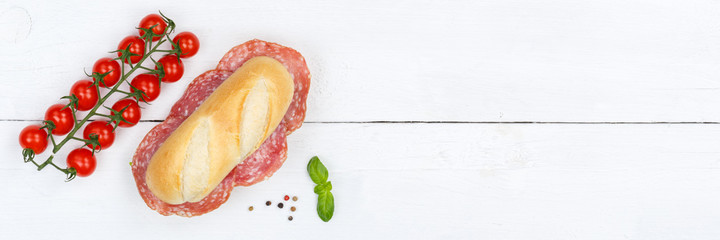 Sub sandwich with salami copyspace copy space banner from above on wooden board